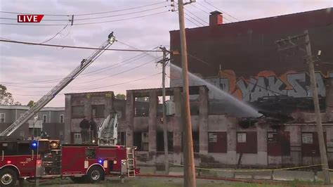Crews continue putting out Saturday night warehouse fire hotspots