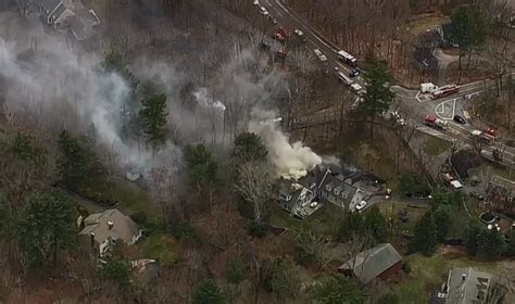 Crews in Burlington work to contain house and brush fire