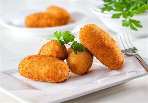 Croquetas. Add to list. Crispy croquetas de jamón are small and unusual Spanish fritters, which consist of a crispy outer shell and a creamy interior. As the central ingredient, they employ a thick variety of buttery béchamel sauce, which is formed into small logs, coated in breadcrumbs and egg wash, and fried until golden and crunchy. 