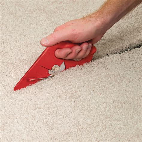 Cut a carpet. Line up your straightedge and cut a small notch on each end with your utility knife. 4. With the ends notched, now go back and realign your straightedge with your markings. Firmly hold the straightedge in place while you guide your utility knife along the edge to score your tile. 5. 