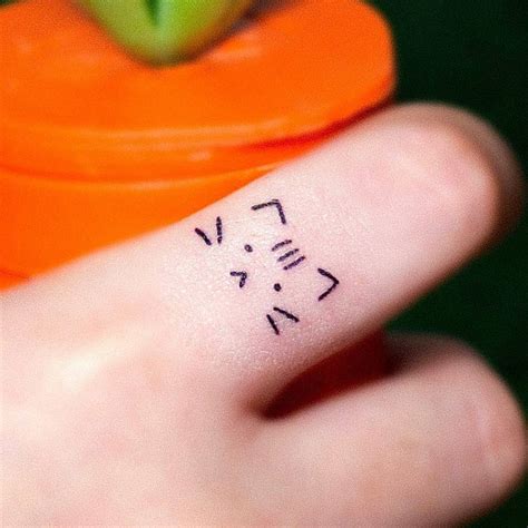 Cute minimalistic cat tattoo located on the finger.