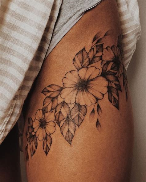 Cute thigh tattoos. 1. Flowers Hold Meaning Thigh Tattoo. Source. Every flower has a special meaning. Sometimes we choose flower tattoos because they remind us of the people who love them. This gorgeous floral ink in black and gray holds a collection of meaningful blooms. I love the shading. 2. Phoenix Thigh Tattoo for Rebirth. 