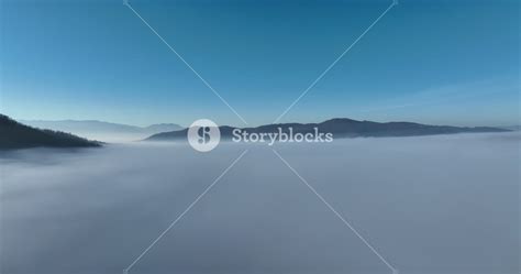 Drone shot into clouds over mountains and lake. Low clouds over high ... - raincitystudios.com