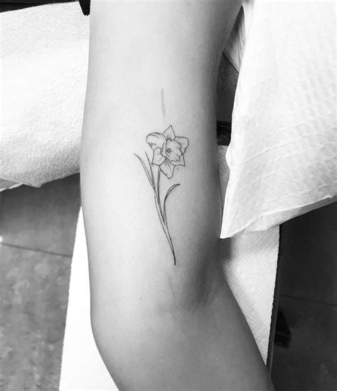 The tattoo focuses on a simple aesthetic with a single line or a fine-line style tattoo in only black and white. ... The March birth flower name tattoo is a common design choice that features your name along with a Daffodil. This tattoo can be done in a really simple style with just the outline of the flower and your name in a single needle .... 