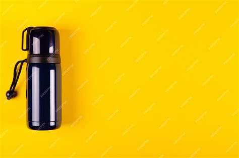 Dark Thermos Composition On Yellow Background. Flat Lay