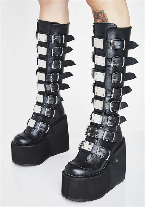 Demonia - Approximate shaft height: 4.9". Shaker-52 is the quintissential Demonia ankle boot. Featuring a daring 4.5" stacked wedge platform that will elevate any outfit from ordinary to extraordinary. The striking black vegan leather adds an edgy touch to your look, while the lace-up front and double buckled ankle straps provide a secure and comfortable ... 