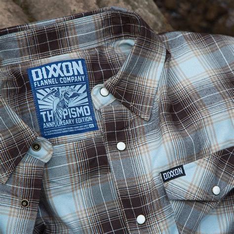 Dixon shirts. Men’s brown, blue, khaki, and white plaid patterned flannel shirt. Full snap button closure. Dual snap button flap chest pockets. Collar-stay buttons. Center box pleat. Machine washable. Signature D-Tech™ polyester blend for … 