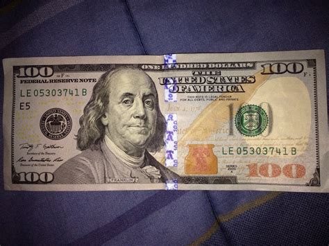 The $5 bill does not have color-shifting ink. However, it does have a large purple 5 on the bottom right corner on the back. Additional security for $100 bill. You can learn how to tell if a $100 bill is real by additional security features. In addition to the standard security features, the $100 bill has a 3D security ribbon woven into the paper.