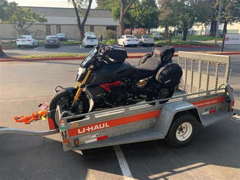 We recommend using the two tie-down points nearest the wheel chock and two at the back of the trailer. 2. Lower the trailer ramp and, with the help of a friend, push the motorcycle up and into the trailer until the front wheel rests against the wheel chock. 3. One person will now have to hold the motorcycle in its upright position..