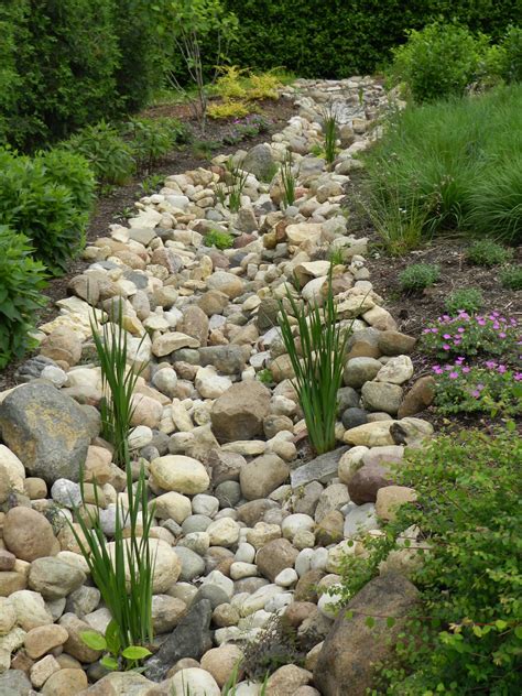 Dry river bed landscaping. Dry creek beds could be your answer. Creating swales or “streams” with materials like river rock can be an easy and beautiful solution to such landscape challenges. River rock swales can be incorporated into both lush and minimal landscape styles. This lovely dry river rock bed also serves as a border between the turf and the … 