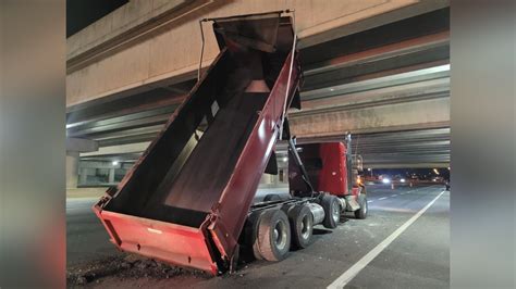 Dump truck with raised bin strikes bridge on Hwy. 404