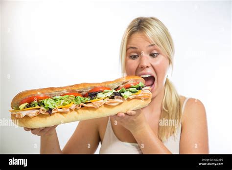 Eating sandwich. Pretty person woman eating large sandwich.