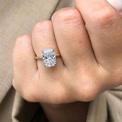 Elongated cushion cut diamond. Two choices are cushion and emerald cuts. The main difference between cushion and emerald cut diamonds is cushion cuts have brilliant cut facets and a squarish shape. Emerald cuts are step-cut diamonds with four sides and cropped corners. They exhibit a warmer glow than cushion cuts because of their elongated facets. 