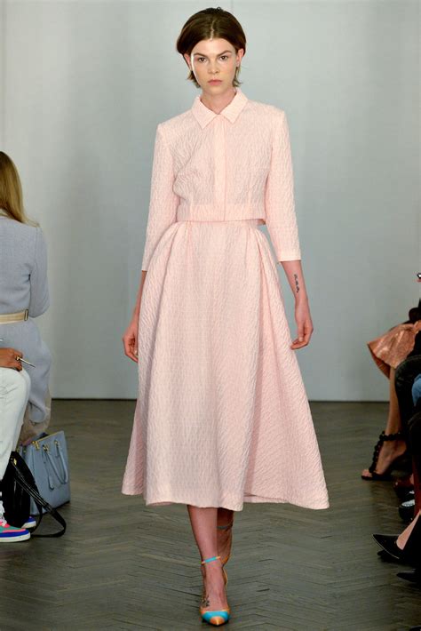 Emilia wickstead. Switzy Dress. Was £1,680 Now £750. The Switzy midi dress in a feminine pink will make an elegant statement thanks to the cape-like sleeves that cascade dramatically down either side. It's cut from a textural double crepe in a figure-hugging silhouette and has sculptural padded shoulders. Size. 