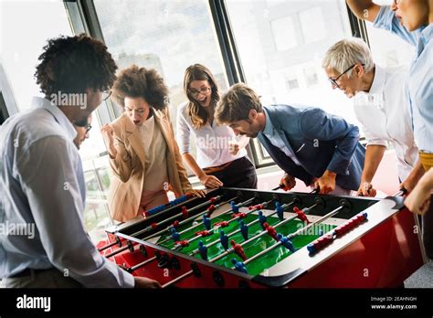 Employees Playing Table Soccer Indoor Game in the Office during Break Time Stock Photo Image