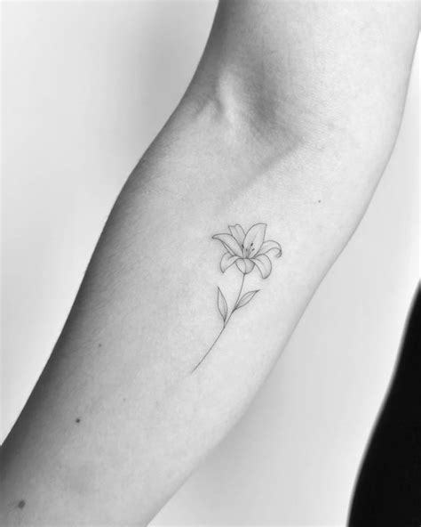 FIne line lily flower tattoo located on the forearm.