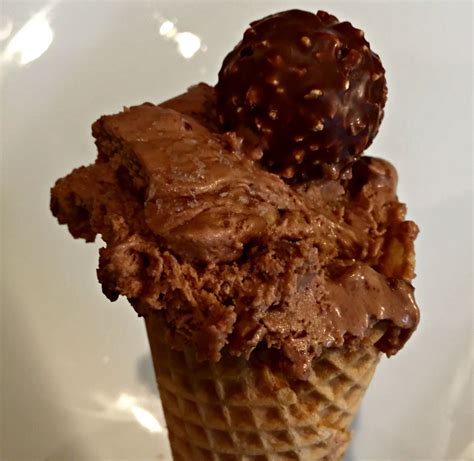 Ferrero rocher ice cream. Add the hazelnuts halfway through the churning process. Once the volume has increased by half and reached a soft serve consistency, transfer the mixture into an airtight container and let harden in the freezer for at least 30 minutes before serving. Decorate with swirls of Nutella and crushed Ferrero Rocher balls. 