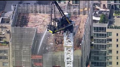 Fire on New York construction crane causes arm to collapse and hit a building as it falls