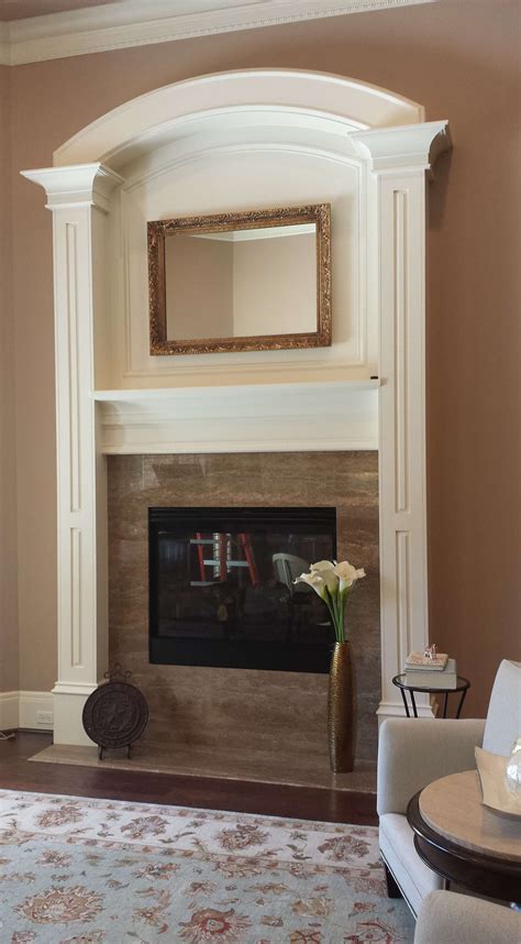 Fireplace redesign. Photo: homebydesign.nc. The floor-to-ceiling brickwork emphasizes this room’s off-center fireplace and instantly draws the eye upwards. The brick is painted the same muted hue as the walls for a clean and harmonious look. The black-painted mantel and hearth add dramatic contrast, making this off-center fireplace feel chic. 