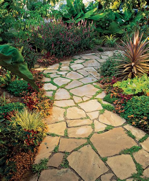 Flagstone pathway. Patios, outdoor fireplaces, outdoor kitchens, pathways, and retaining walls in a variety of materials can be every style from the most modern and contemporary to the traditional. Slate grey Banas flagstone walkway laid in herringbone pattern, decorative brick pillars, Flamboro dark armourstone placements, and gardens. 