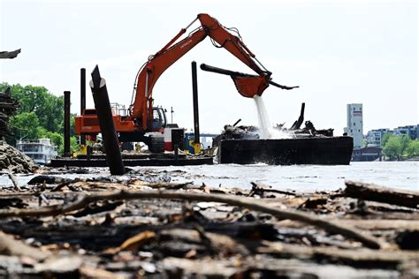 Floating excavator deployed this week to clear Raspberry Island driftwood