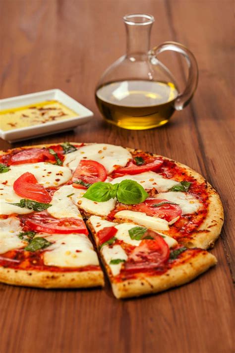 Fresh mozzarella pizza. Cover with a damp cloth and let it prove for 30 minutes. Preheat the oven to its highest setting and add preheat a pizza stone or 2 baking trays. Press the dough out very thinly to make two ... 