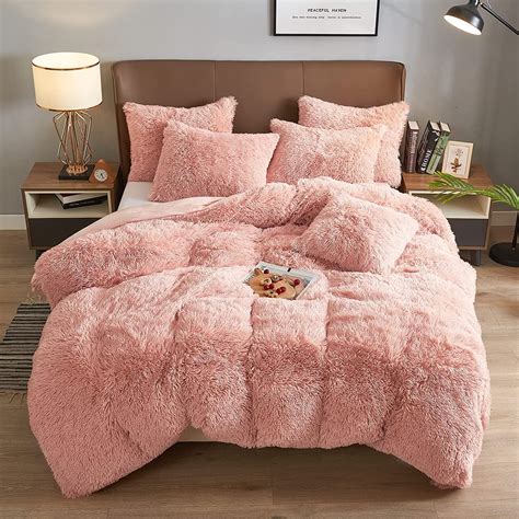 The Fuzzy Peach - Coma Inducer Comforter - Peachy Pink from Byourbed is made of a super soft 500GSM faux rabbit plush for a silky softness you need to feel to believe. On the reverse side of this comforter is a plush flannel in solid white. You'll want to cuddle up with this luxury plush bedding set every night! 