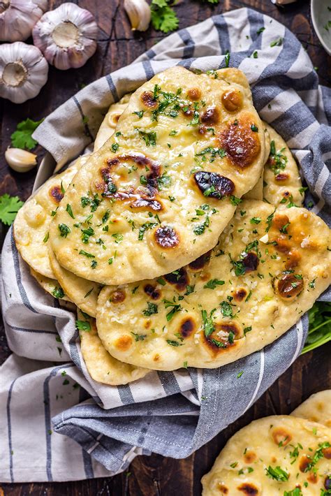 Garlic naan bread. Preheat the oven to 400 F. 9. Place naan on a parchment paper lined baking sheet. 10. Bake for 8-10 mins, until it starts to puff up and turn golden. 11. Flip the bread and bake for another 8-10 mins on the other side. 12. Once cooked, brush the naan with melted butter and garlic. 