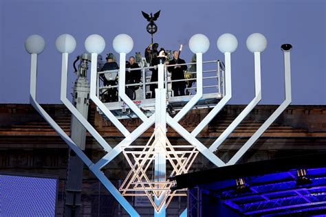Germany’s chancellor lights first Hanukkah candle on a huge menorah at Berlin’s Brandenburg Gate