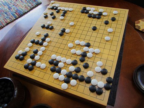 Go is an adversarial game between two players with the objective of capturing territory. That is, occupying and surrounding a larger total empty area of the board with one's stones than the opponent. [21] As the game progresses, the players place stones on the board creating stone "formations" and enclosing spaces..
