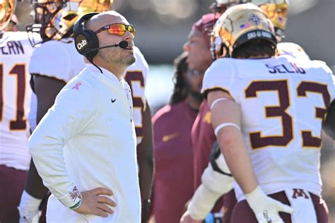 Gophers AD Mark Coyle stands behind football coach P.J. Fleck