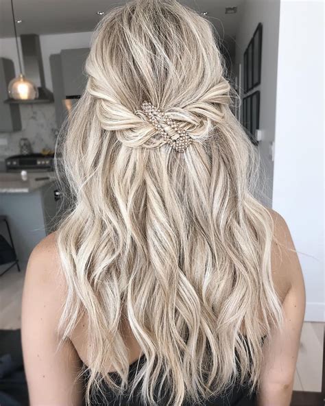 Achieving this style is super simple; you only need your favorite hair serum, a good blow dryer, and a round brush. There is no need for specific perfectly crafted curls or waves because the look plays with natural texture and an innately ‘pretty’ vibe. 2. Double Braid With Large Wildflower Flower Crown.. 