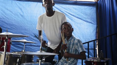 Haitian students play drums and strum guitars to escape hunger and gang violence