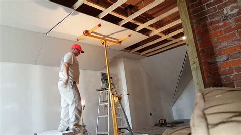 Hanging drywall on ceiling. Watch the craftsman raise a 12' sheet of sheetrock to a high ceiling using a hoist equipped with an optional extension. 
