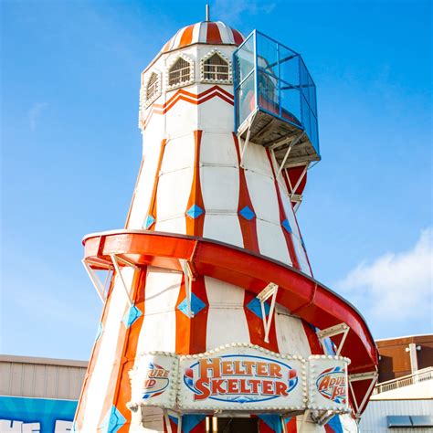 RM BFJJ8G - fairground helter skelter ride tower flying union jack flag on bright sunny day. RF HPJ49K - red and yellow helter skelter fairground ride, slide. The sky is blue and the words helter skelter are spelled out in lights on the front of the slide. RM C8AFDW - Helter skelter fairground ride.. 