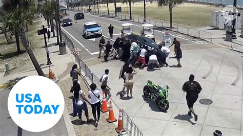 Heroic onlookers lift car to free trapped motorcyclist - USA Today