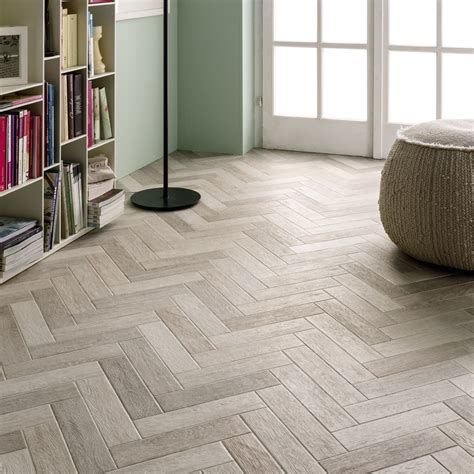 Herringbone flooring. The sixth step is to start the second row. Cut the first board in half, lengthwise, and lay it. against the end of the first row. To create the herringbone pattern, continue laying the. boards, alternating between full-length and half-length panels. Make sure to stagger the. 