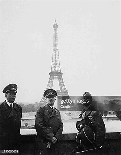 Hitler standing in front of the eiffel tower