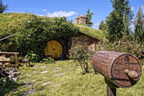 Hobbit house. Matamata, New Zealand - July, 2018: Hobbiton movie set created to film Lord of the Rings and The Hobbit. Hobbit house with orange door. Gnome houses vector icons, cartoon fantasy building made of plants, vegetables and trees with green leaves. Fairy, gnome or elf cute homes in pumpkin, mushroom, carrot, stump and pot isolated set. 
