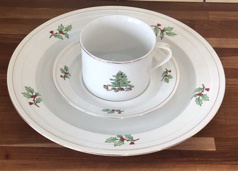Set for four of Holiday Hostess pattern Tienshan china dishes with Christmas tree and holly on white porcelain. There are four each of cup and saucer sets, salad plates, dinner plates. The entire set is in very good, gently used condition. There's a few light scratches and utensil marks, no chips or cracks. item #u101636. SOLD.. 
