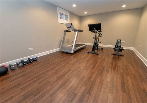 Home gym flooring. In this no-nonsense, fully loaded home gym from M. Lavender Interiors, a palette of grays and taupes and hard-wearing wood-effect vinyl flooring keep the focus … 