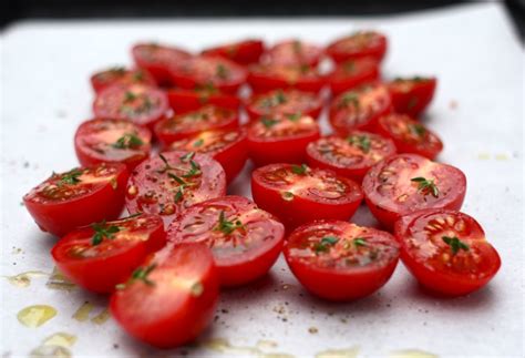 Hot tomatoes. Place the tomato halves in a large mixing bowl. Add minced garlic, salt, pepper, fresh thyme, and spices. Drizzle a generous amount, about ¼ cup or more, quality extra virgin olive. Toss to coat. Transfer the tomatoes to a baking sheet with a rim. Spread the tomatoes in one single layer, flesh side up. 