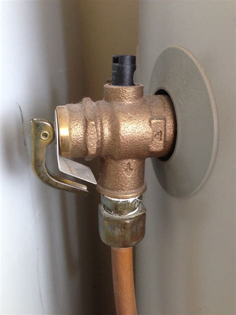 Hot water heater pressure relief valve. The T&P valve is usually located high on the side or on top of the tank. It’s connected to a pipe that runs down the length of the water heater and stops a few inches above the floor. The valve itself consists of a flat, inch-and-a-half-long lever that lifts and lowers when water is released to reduce the temperature and pressure within the tank. 