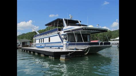 This Floating Cabin Boat House For Sale on Norris Lake Tennessee features Approx 610sqft of Interior Living Space with 2 Loft Bedrooms 1 with a King Bed, the other with a Twin Bed, 1 Bath with a Vanity Sink, Marine Head, and Shower plus 2 Futons in a Living Room, a Kitchen with Refrigerator, Oven/Range, Microwave, Island Bar, Window Air …. 