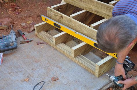 How to anchor deck stairs to ground. For the run, the 11-in. treads will have a 1/2-in. overhang, so the stringer’s tread depth will be marked and cut at 10-1/2 in. Except for the bottom landing, every tread has 3/4-in. decking; to keep the rise at the bottom the same as the others, a 3/4-in. heel cut is made to account for the missing decking at ground level. 