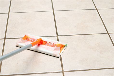 How to clean floor tile. Stay away from metal brushes, as this can scratch your tile and pull out grout. Gently wipe away the mixture with the rag, and rinse with water. Once it’s rinsed, the best way to remove the water is to use a shop vac and vacuum up the dirty water. This will help pull the dirty water and soap film off the floor. 