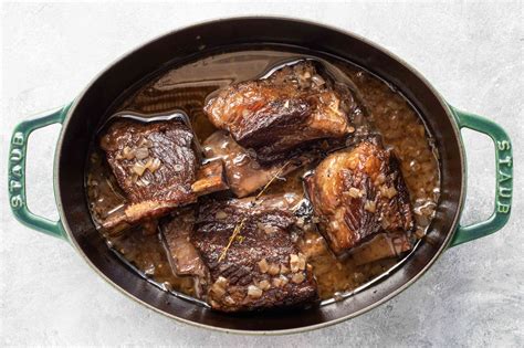 How to cook beef short ribs. Preheat oven 275 F. In a small bowl, whisk together olive oil, garlic salt, and pepper. Using gloved hands, rub the oil and spice mixture all over the short ribs. Preheat a skillet over medium high heat. Do not add any oil. When skillet is hot, sear the short ribs to develop a nice brown crust. 