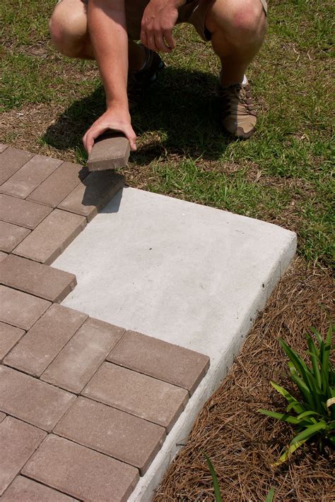 How to install pavers. Overlay pavers offer plenty of options to transition into other walkways. These include: 1) Grinding down the concrete on the ends to adjust for any height differences. 2) Pouring concrete edging to create a softer edge between walkways. 3) As a last resort, breaking up and re-pouring the concrete near the transitions. 