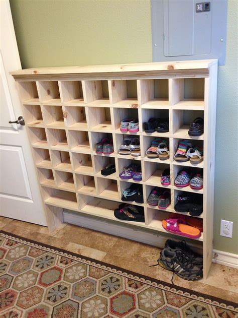 How to make a shoe shelf with shoe boxes. Tired of tripping over shoes at the front door? This DIY shoe storage bench is the perfect solution for your entryway! The cushion top provides comfortable seating while you remove your shoes, and the wire bins below hold plenty of pairs. Get the free woodworking plans to make your own shoe storage bench here! DIY Garage Shoe Storage 