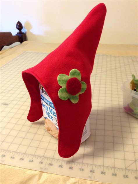 Sew on the gnome nose and and add locks to the bottom for a seamless look. Bend over the wire at both ends, stuff the mitten, and insert the wire into mitten all the way in. Stuff the arm and slide about three-quarters of an inch into the mitten. Sew the mitten to the arm or secure with glue..